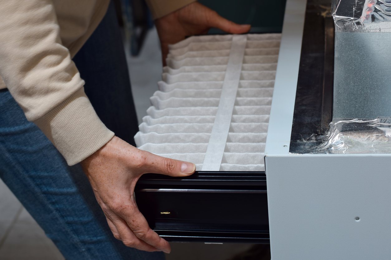 Woman is replacing furnace filter at home Air Condition Service repair
